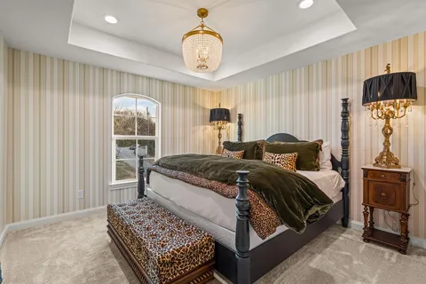 a spacious bedroom with a bed and a chandelier