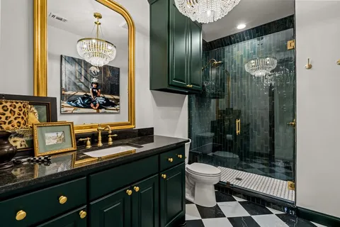 a bathroom with a sink a toilet a mirror and shower