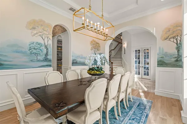 a dining room with furniture a chandelier and wooden floor