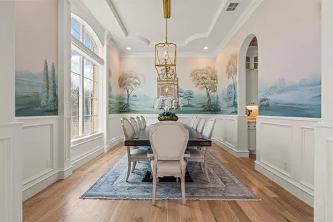 a dining room with furniture a chandelier and wooden floor