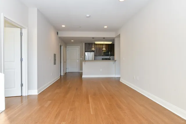a view of a big room with wooden floor and windows