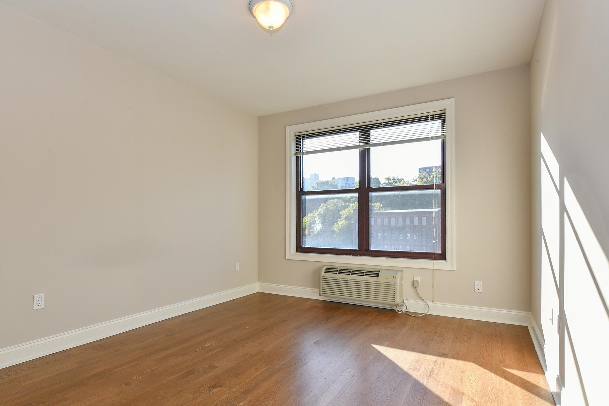 100 Marshall Street, Unit 608 Hoboken, NJ 07030 - Photo 10 of 22 an empty room with wooden floor and windows