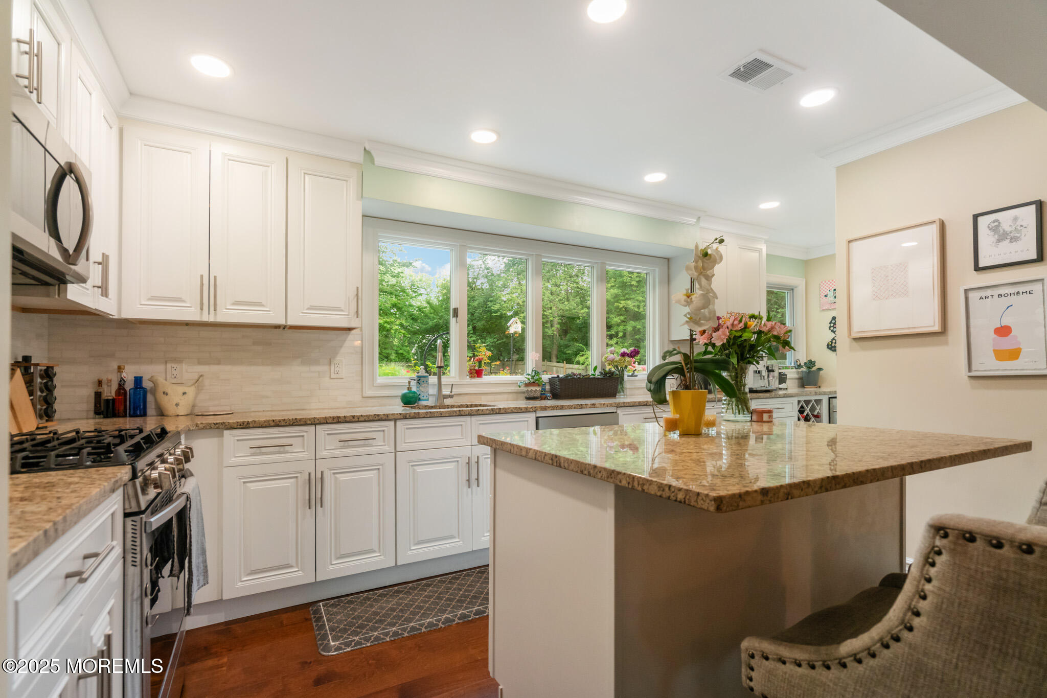 a kitchen with kitchen island granite countertop a sink cabinets stainless steel appliances and a counter top space