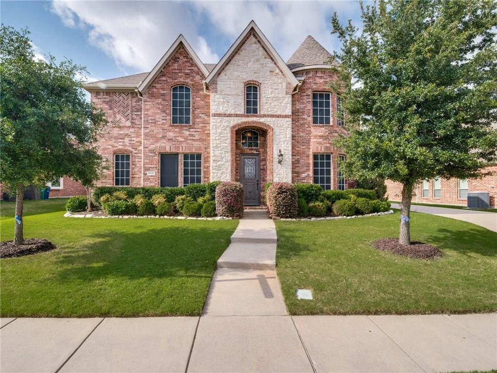 a front view of a house with a yard and trees