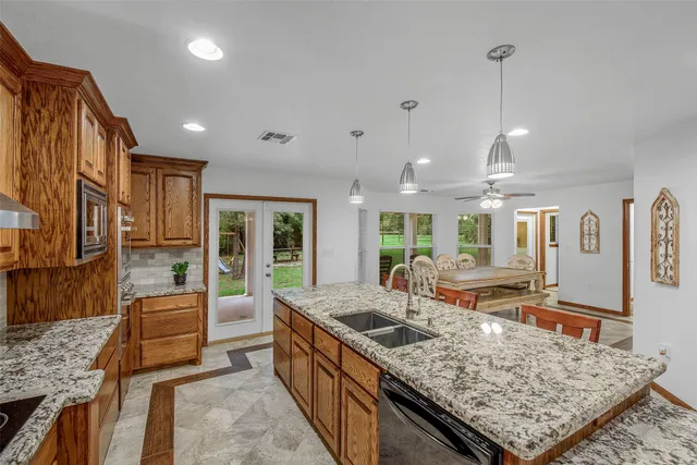 a kitchen with granite countertop sink stove and refrigerator