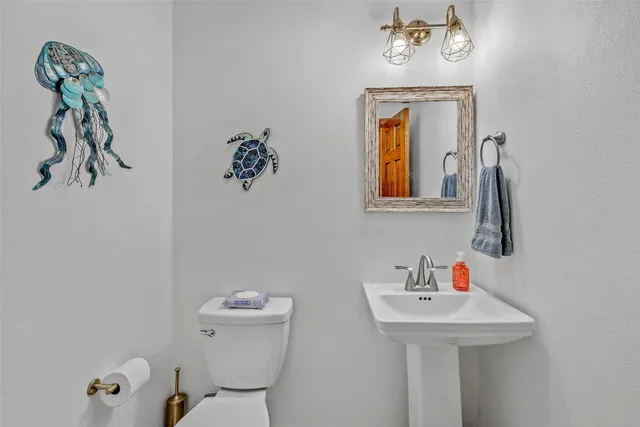 a bathroom with a sink mirror and toilet