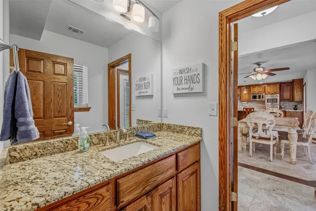a bathroom with a granite countertop sink and a mirror