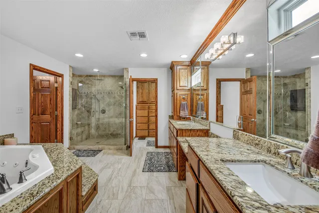 a spacious bathroom with a granite countertop tub sink and mirror