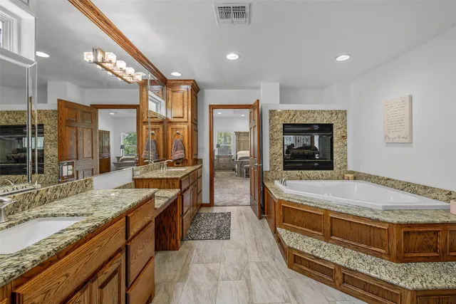 a spacious bathroom with a granite countertop tub sink and mirror