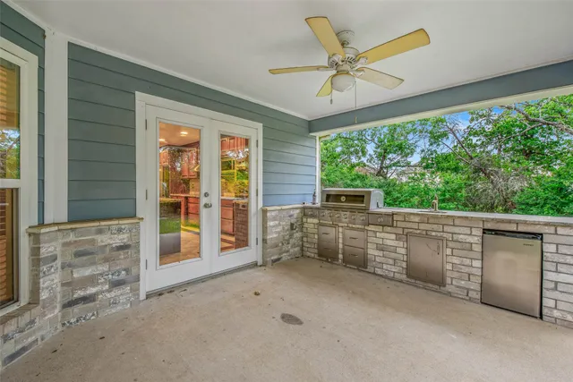 an empty room with windows fan and front door