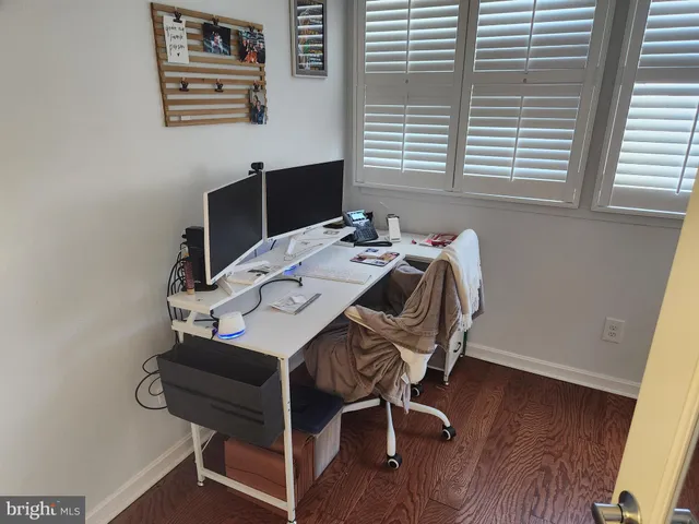 a view of a workspace with furniture and a window
