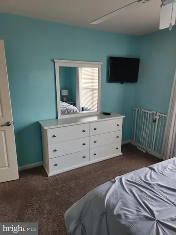 a bedroom with a bed and a mirror on dresser