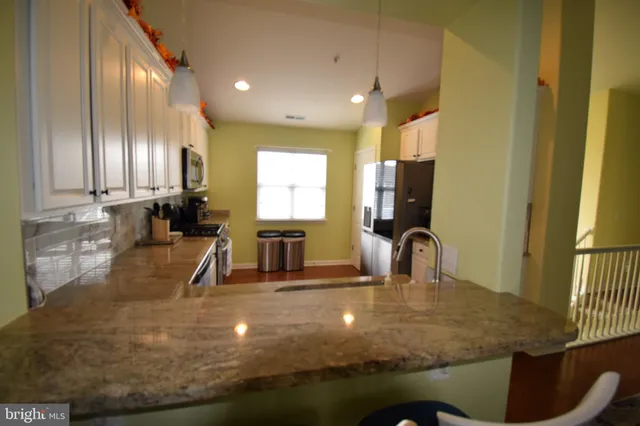 a kitchen with kitchen island a sink appliances and a counter top space