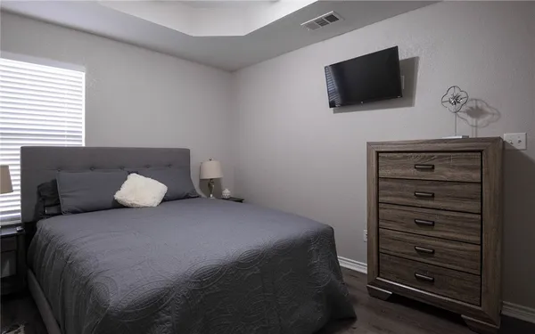 a bedroom with a bed a flat screen tv and a couch