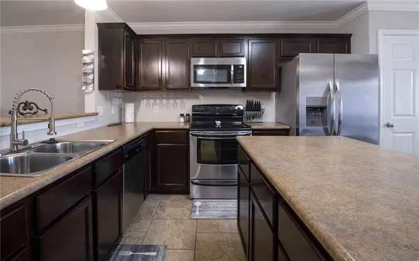 a kitchen with stainless steel appliances granite countertop a sink a stove top oven and refrigerator