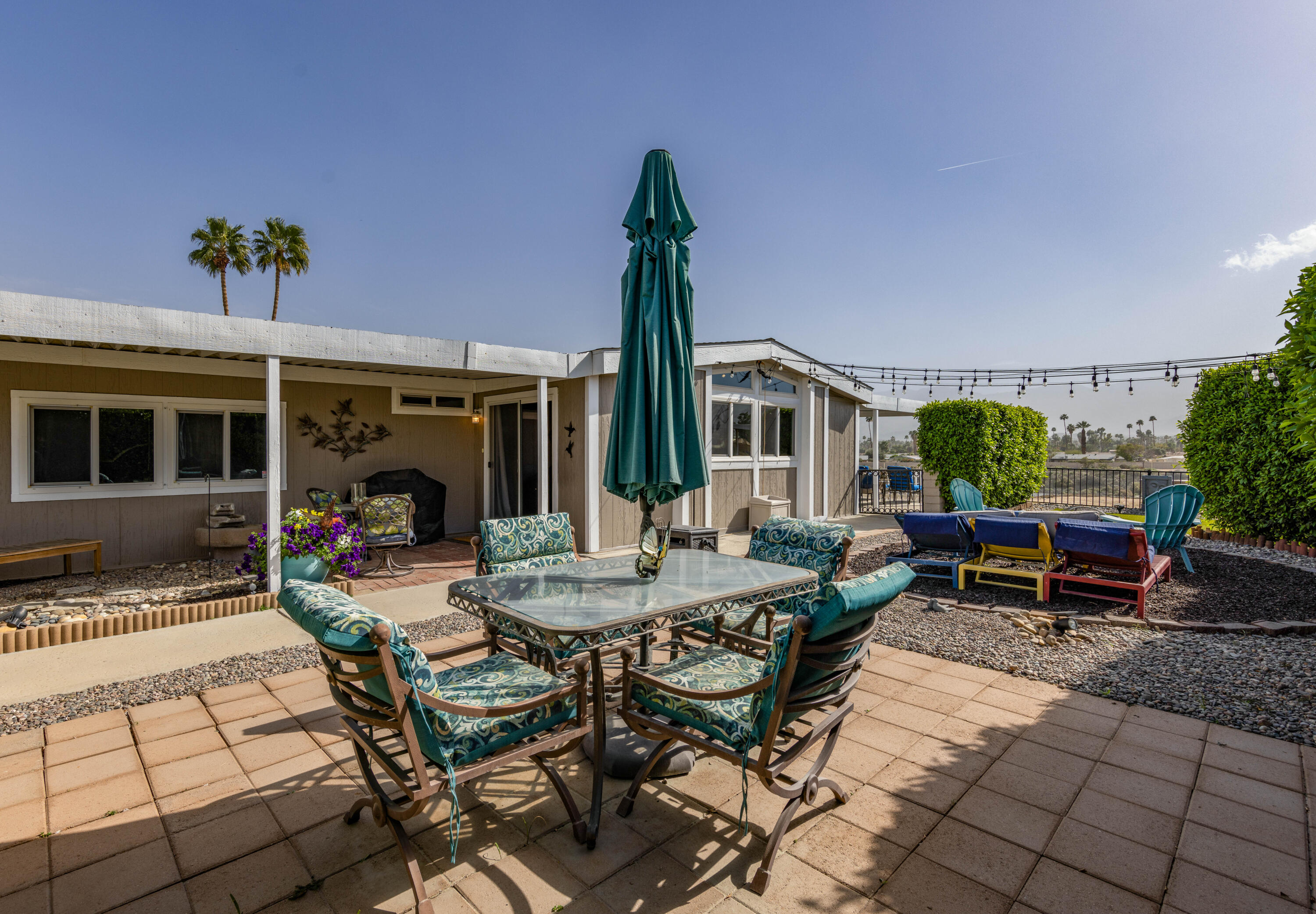 Undisclosed Address Palm Desert, CA 92260 - Photo 31 of 41 a view of a patio with table and chairs potted plants with wooden floor and fence