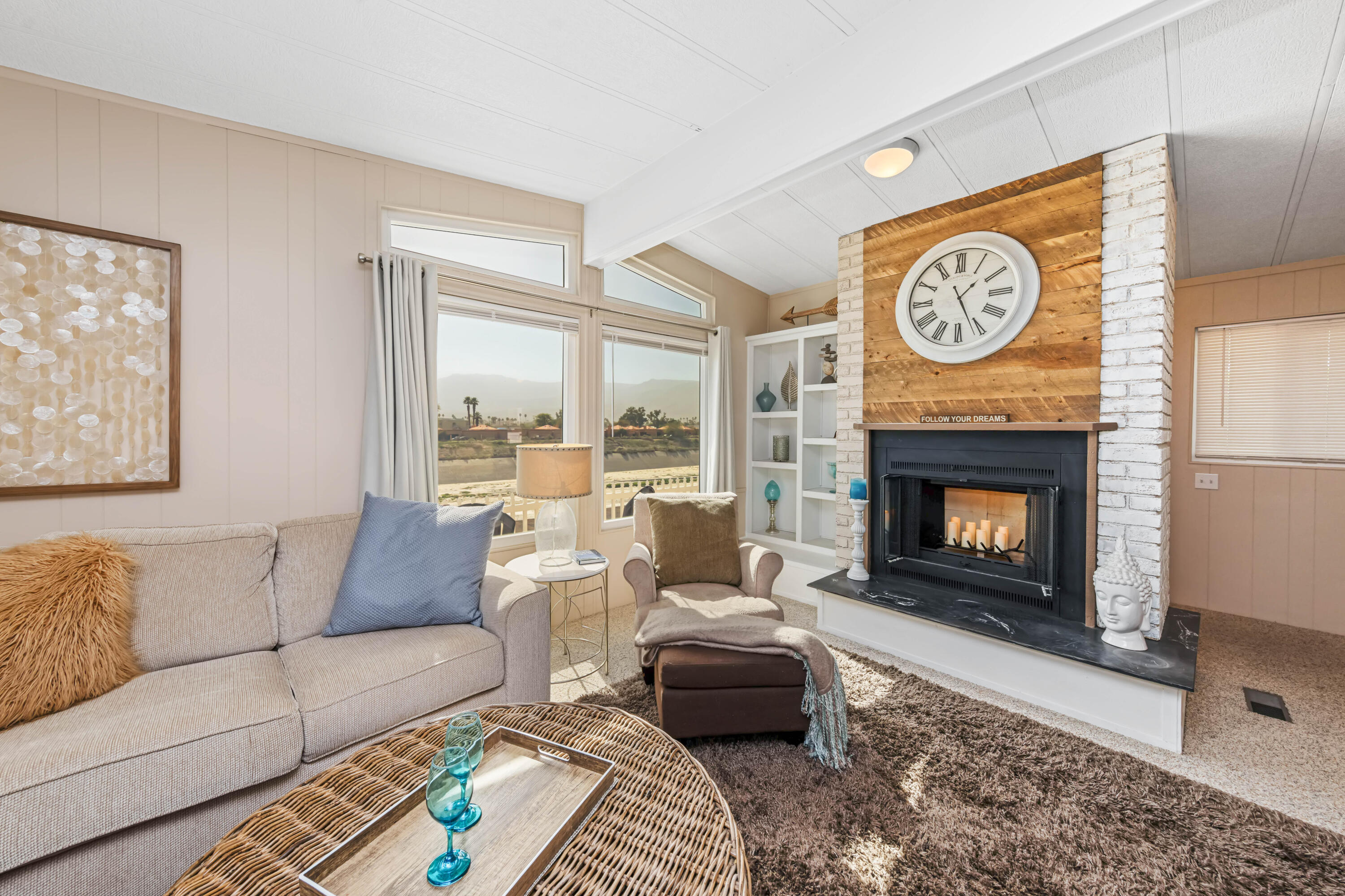 Undisclosed Address Palm Desert, CA 92260 - Photo 8 of 41 a living room with furniture a clock and a fireplace
