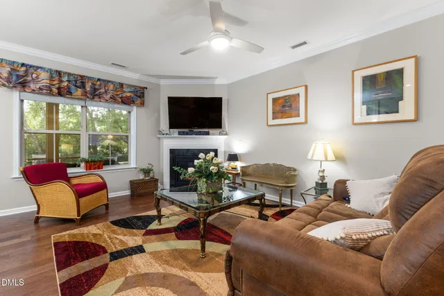 a living room with furniture a flat screen tv and large window
