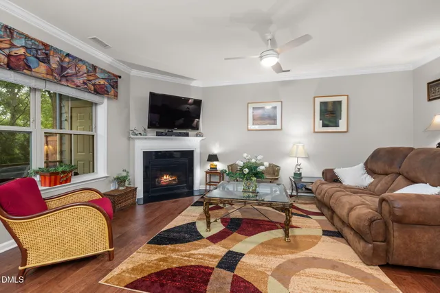 a living room with furniture a flat screen tv and a fireplace