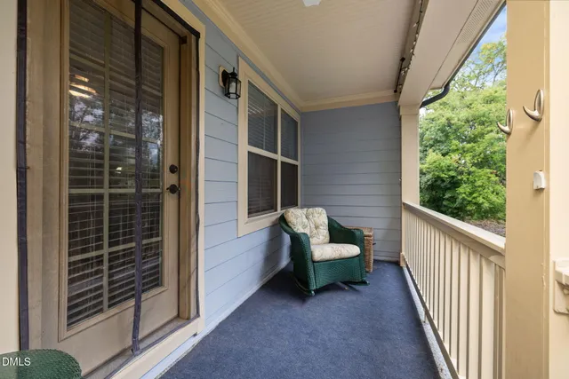 a view of a porch with furniture and floor to ceiling window