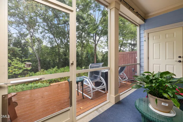 a view of a patio with table and chairs potted plants with wooden floor and fence