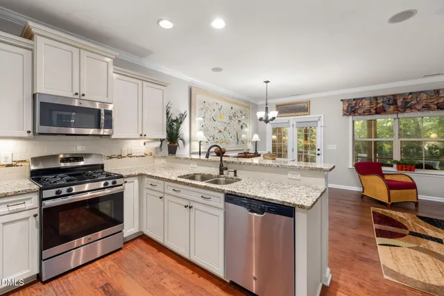 a kitchen with stainless steel appliances granite countertop a stove a sink and a microwave