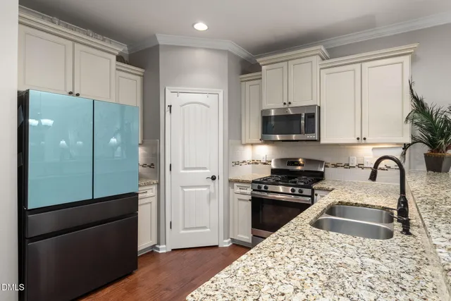 a kitchen with granite countertop a refrigerator stove and sink