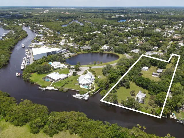 an aerial view of residential houses with outdoor space and river