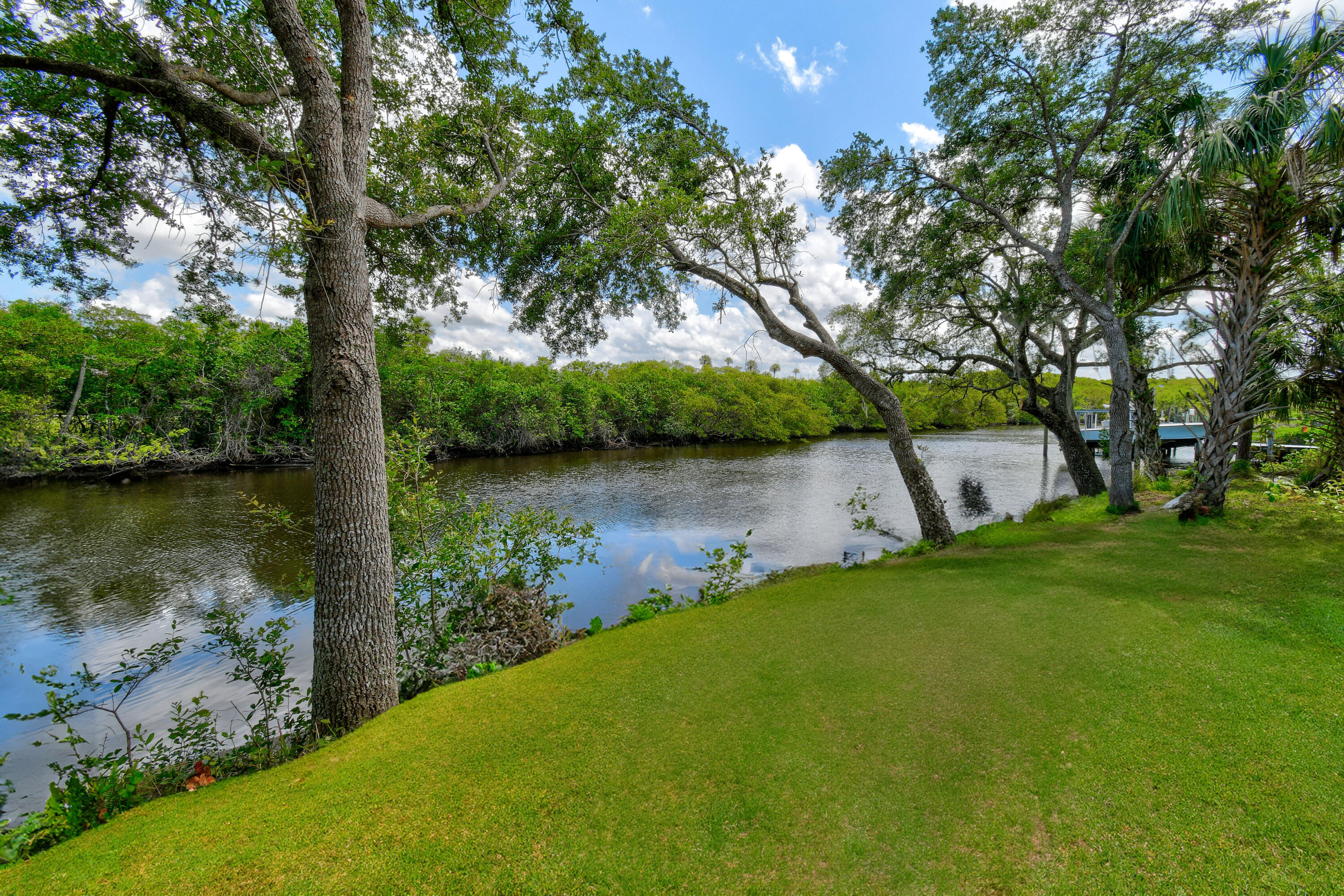 332 Southwest Salerno Road Stuart, FL 34997 - Photo 12 of 17 a backyard of a house with lots of green space and lake view