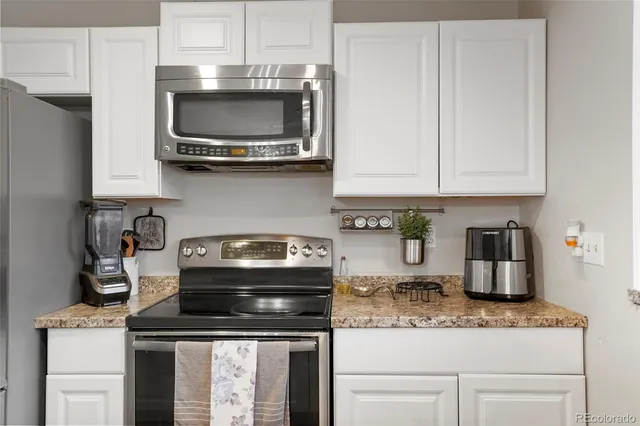 a kitchen with stainless steel appliances granite countertop a stove and a microwave