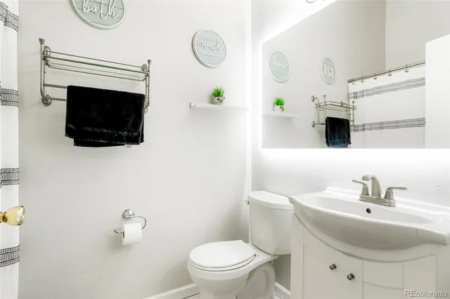 a bathroom with a sink toilet and a mirror