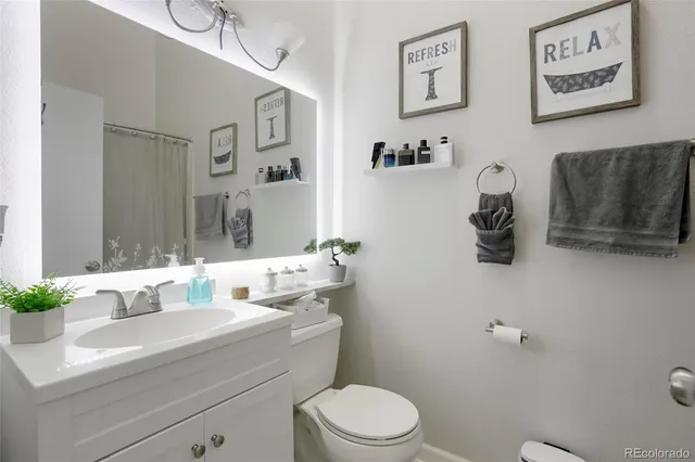 a bathroom with a sink mirror vanity and toilet