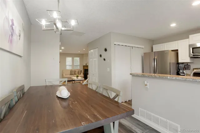 a view of a dining room and kitchen island with wooden floor