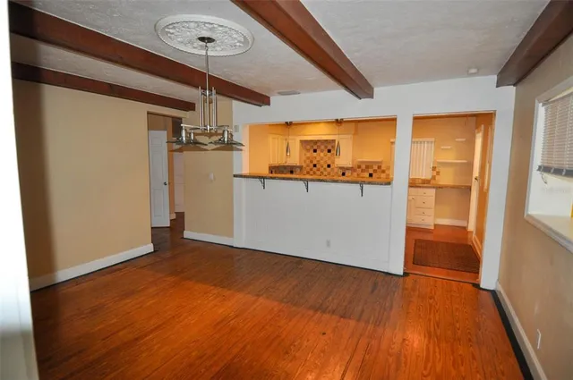 a view of a room with wooden floor and a window