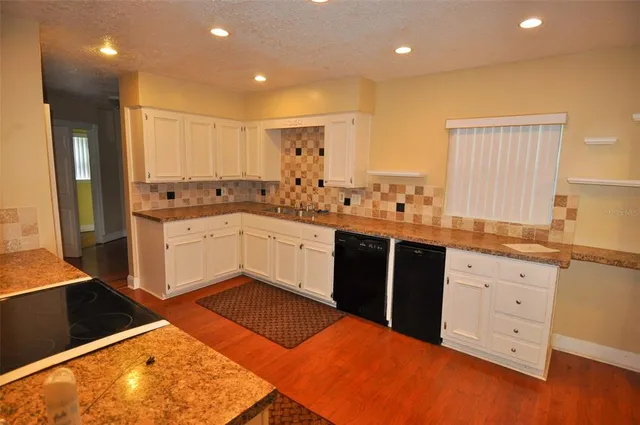 a kitchen with stainless steel appliances kitchen island granite countertop a sink and cabinets