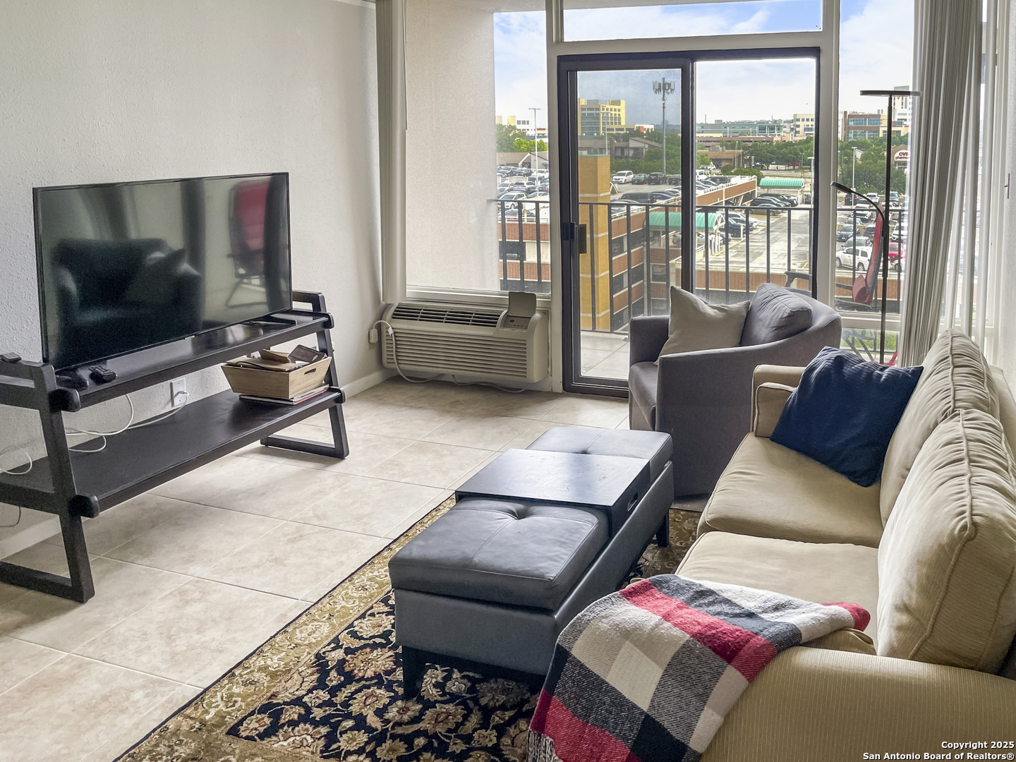 7701 Wurzbach Road, Unit 703 San Antonio, TX 78229 - Photo 2 of 28 a living room with furniture and a flat screen tv