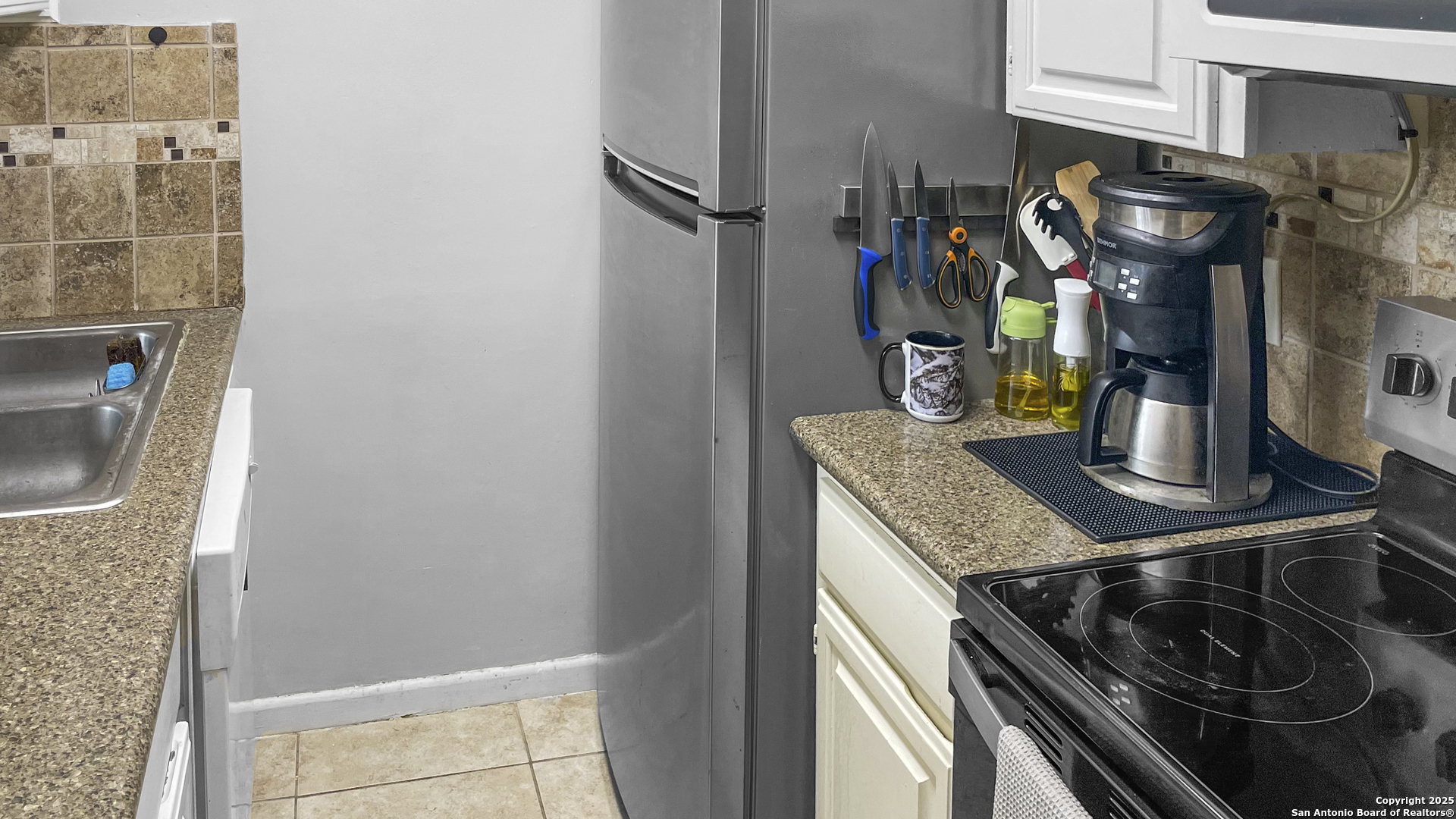 7701 Wurzbach Road, Unit 703 San Antonio, TX 78229 - Photo 10 of 28 a kitchen with a stove and a sink