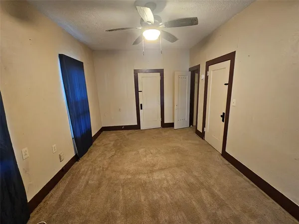 a room with a chair and white cabinets