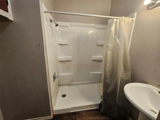 a bathroom with a sink a mirror and shower