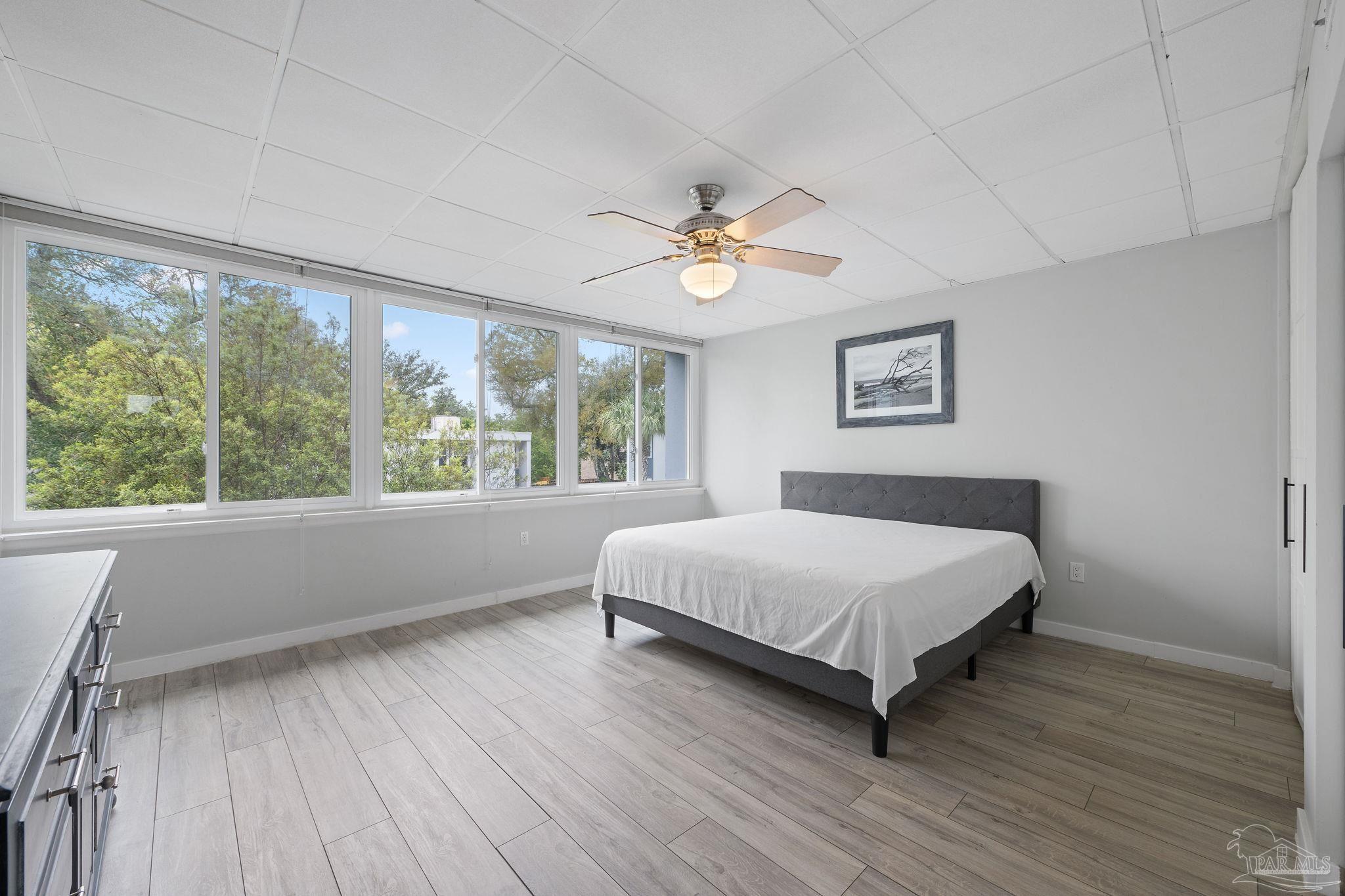 201 Pensacola Beach Road, Unit D24 Gulf Breeze, FL 32561 - Photo 14 of 29 a bedroom with a large bed window and a ceiling fan