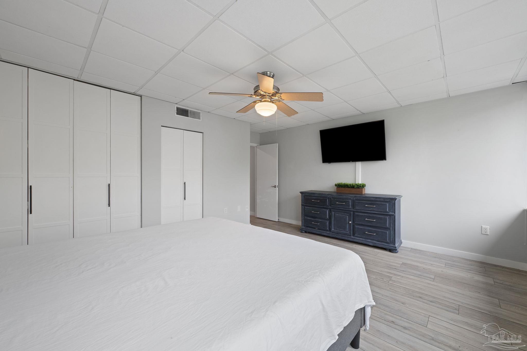 201 Pensacola Beach Road, Unit D24 Gulf Breeze, FL 32561 - Photo 16 of 29 a bedroom with a bed and a flat screen tv