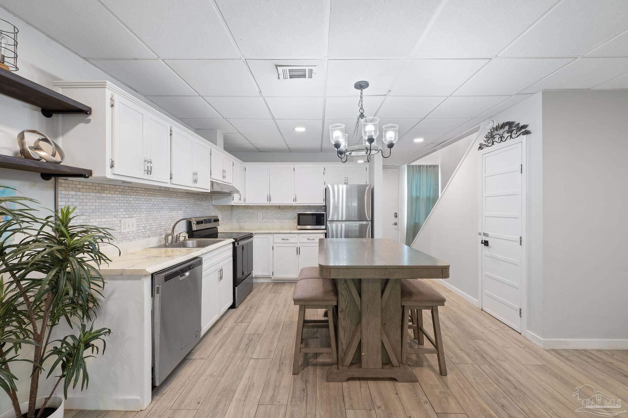 201 Pensacola Beach Road, Unit D24 Gulf Breeze, FL 32561 - Photo 3 of 29 a kitchen with a table and chairs in it