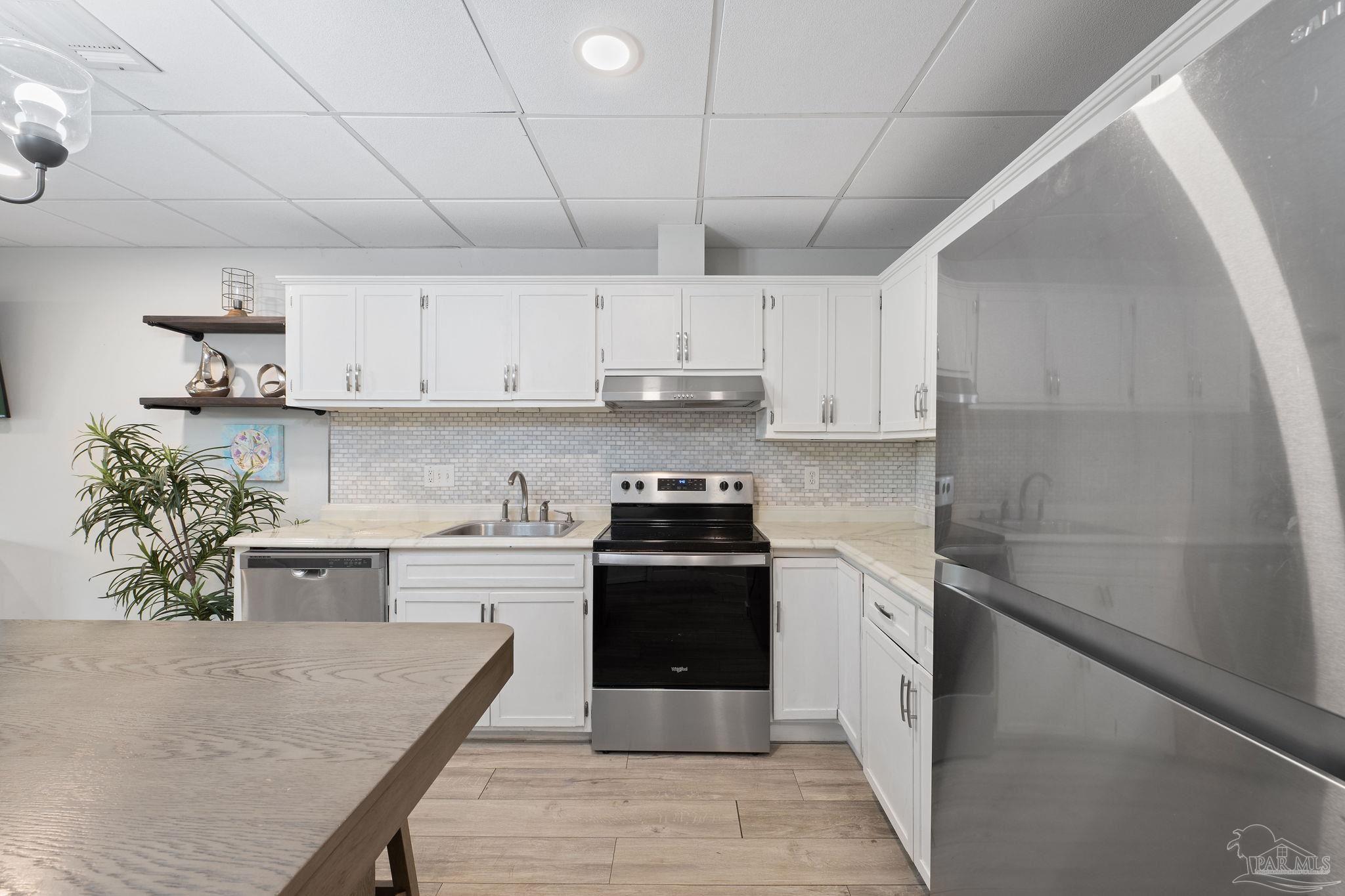 201 Pensacola Beach Road, Unit D24 Gulf Breeze, FL 32561 - Photo 4 of 29 a kitchen with a stove sink and cabinets