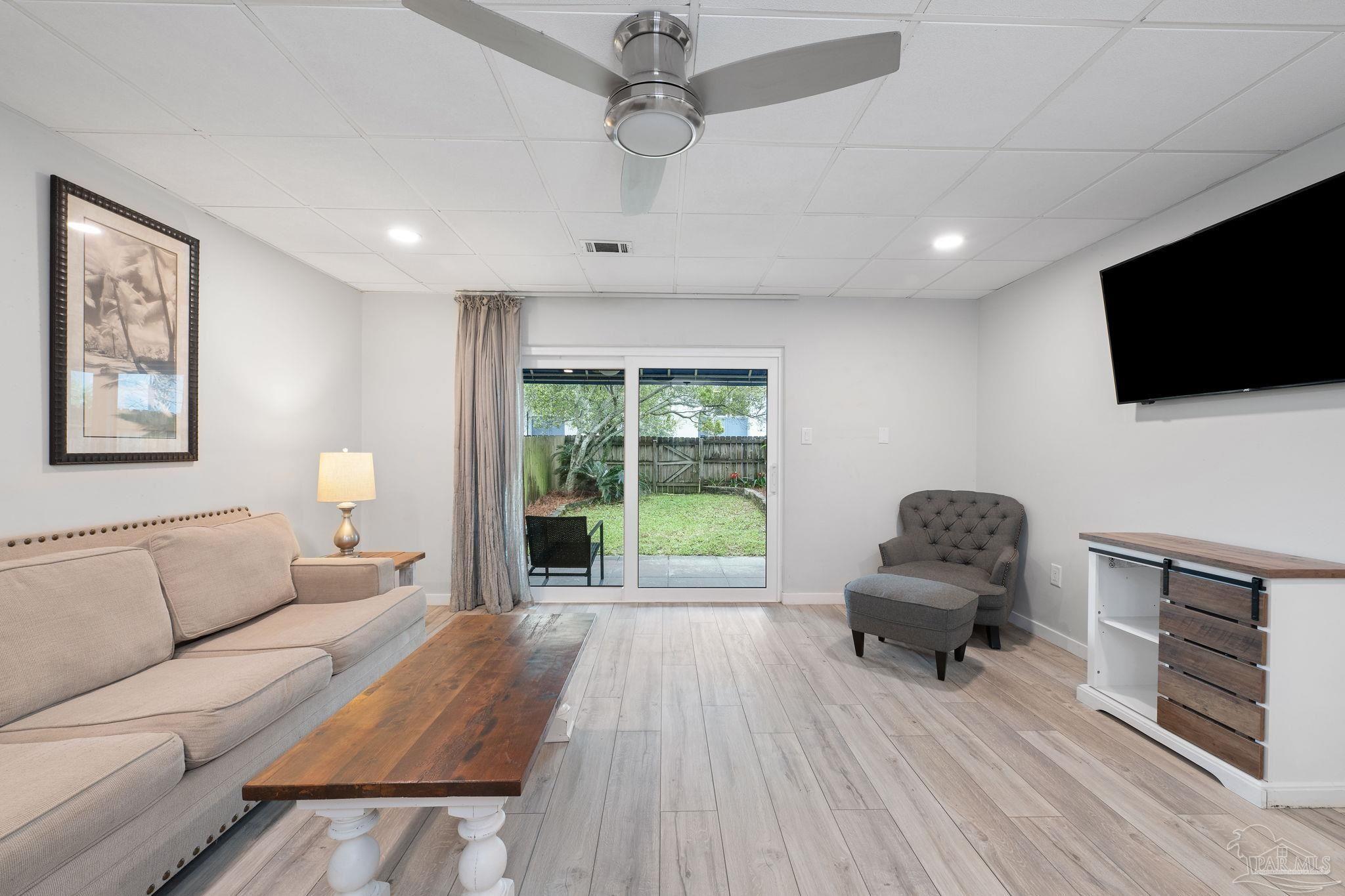 201 Pensacola Beach Road, Unit D24 Gulf Breeze, FL 32561 - Photo 7 of 29 a living room with furniture a flat screen tv and a fireplace