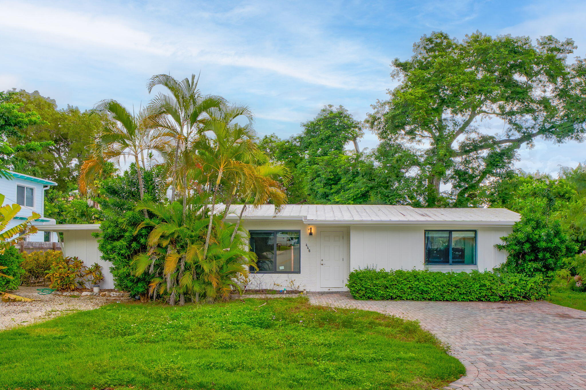 a front view of a house with a garden and plants