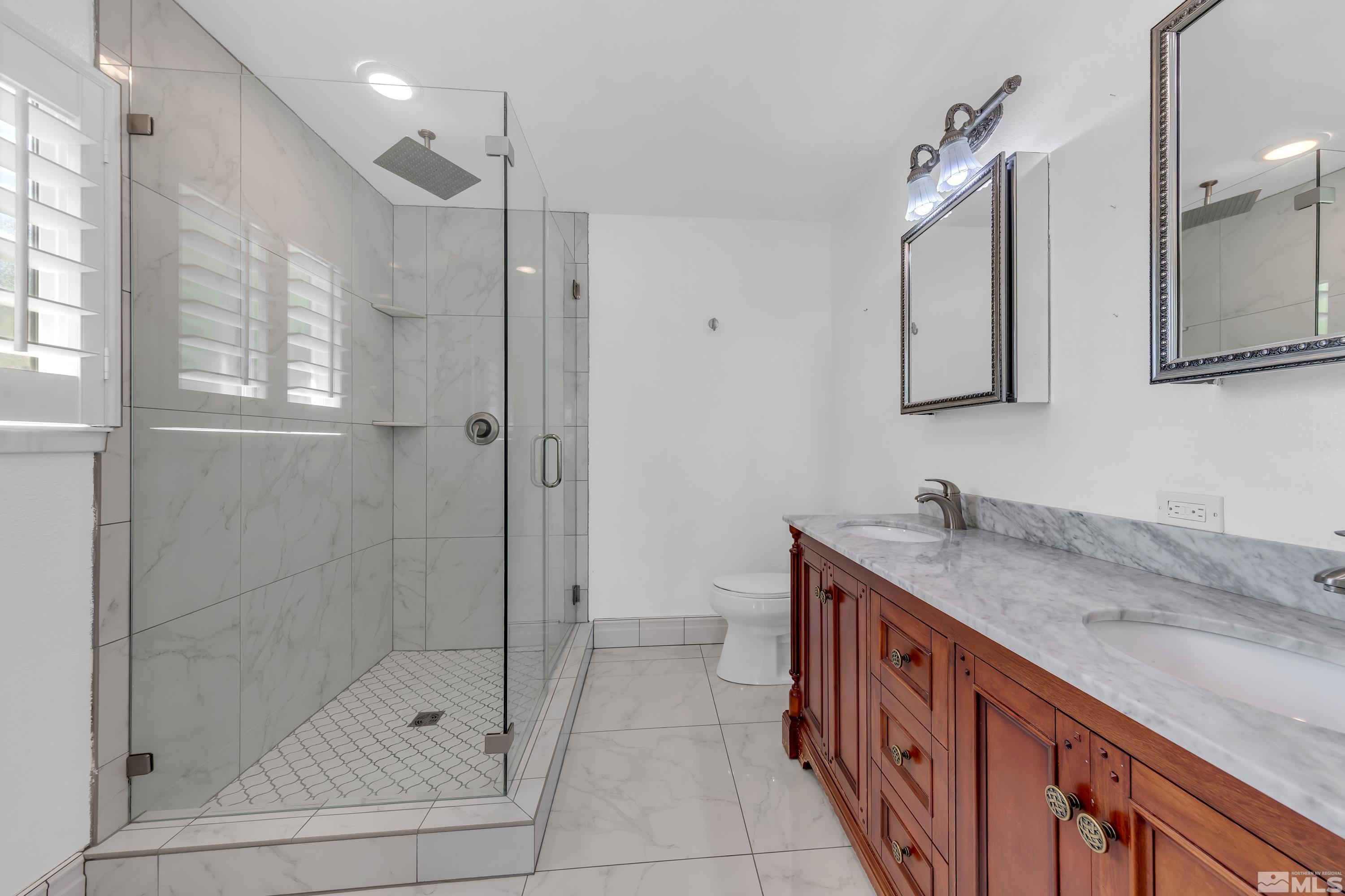 2370 Fireside Circle Reno, NV 89509 - Photo 25 of 29 a bathroom with a granite countertop sink a mirror and a shower