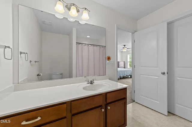 a bathroom with a granite countertop sink toilet and a mirror