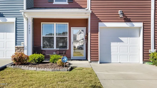 a front view of a house with a yard and potted plants