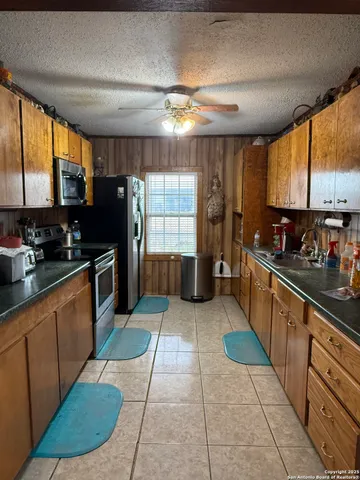 a large kitchen with stainless steel appliances granite countertop a refrigerator and a sink