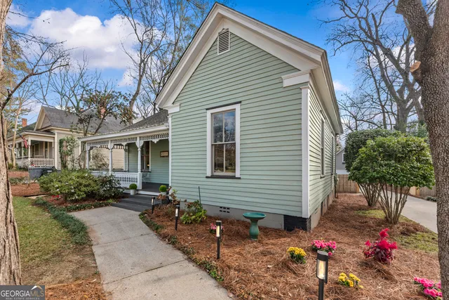 a front view of house with yard and trees in the background